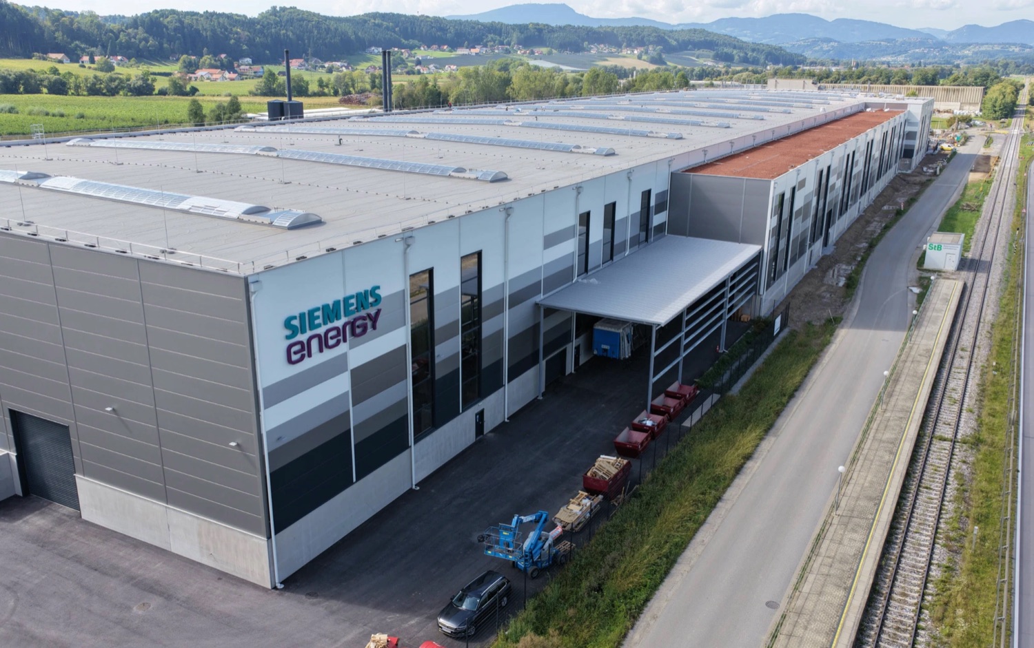 Aerial view of the Siemens Energy production hall with skylights and its rail siding.